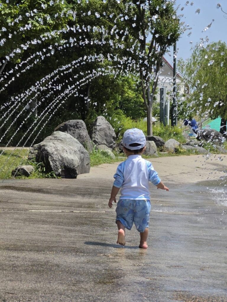 トンネル状の噴水の中を楽しそうに歩く息子